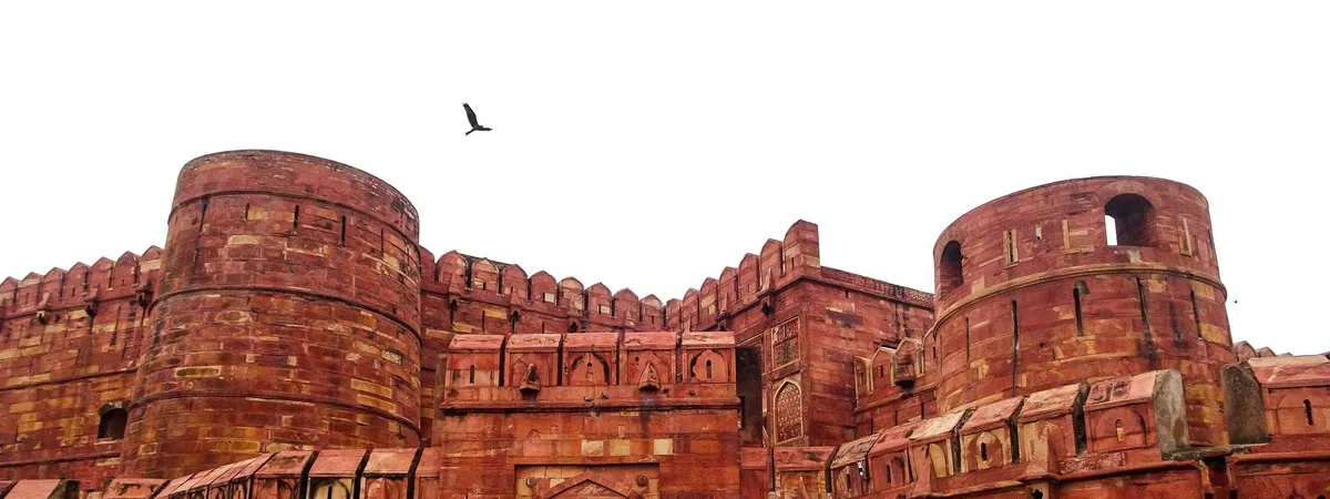 The red sandstone ramparts and bastions of Agra Fort against a bright sky