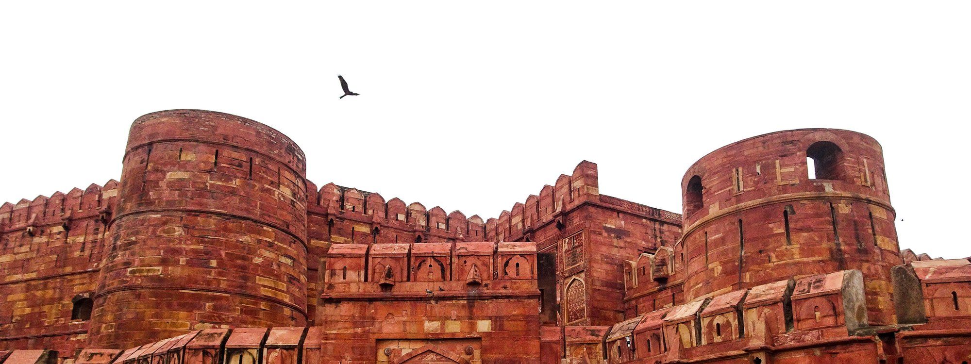 The red sandstone ramparts and bastions of Agra Fort against a bright sky