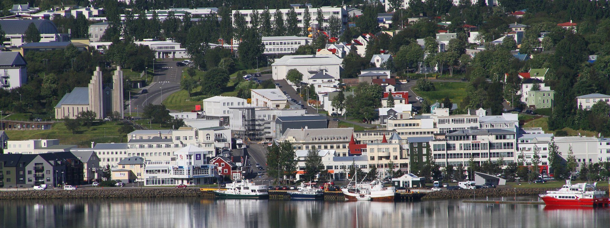 Colorful downtown Akureyri along Eyjafjörður fjord with Akureyrarkirkja church on the hill above
