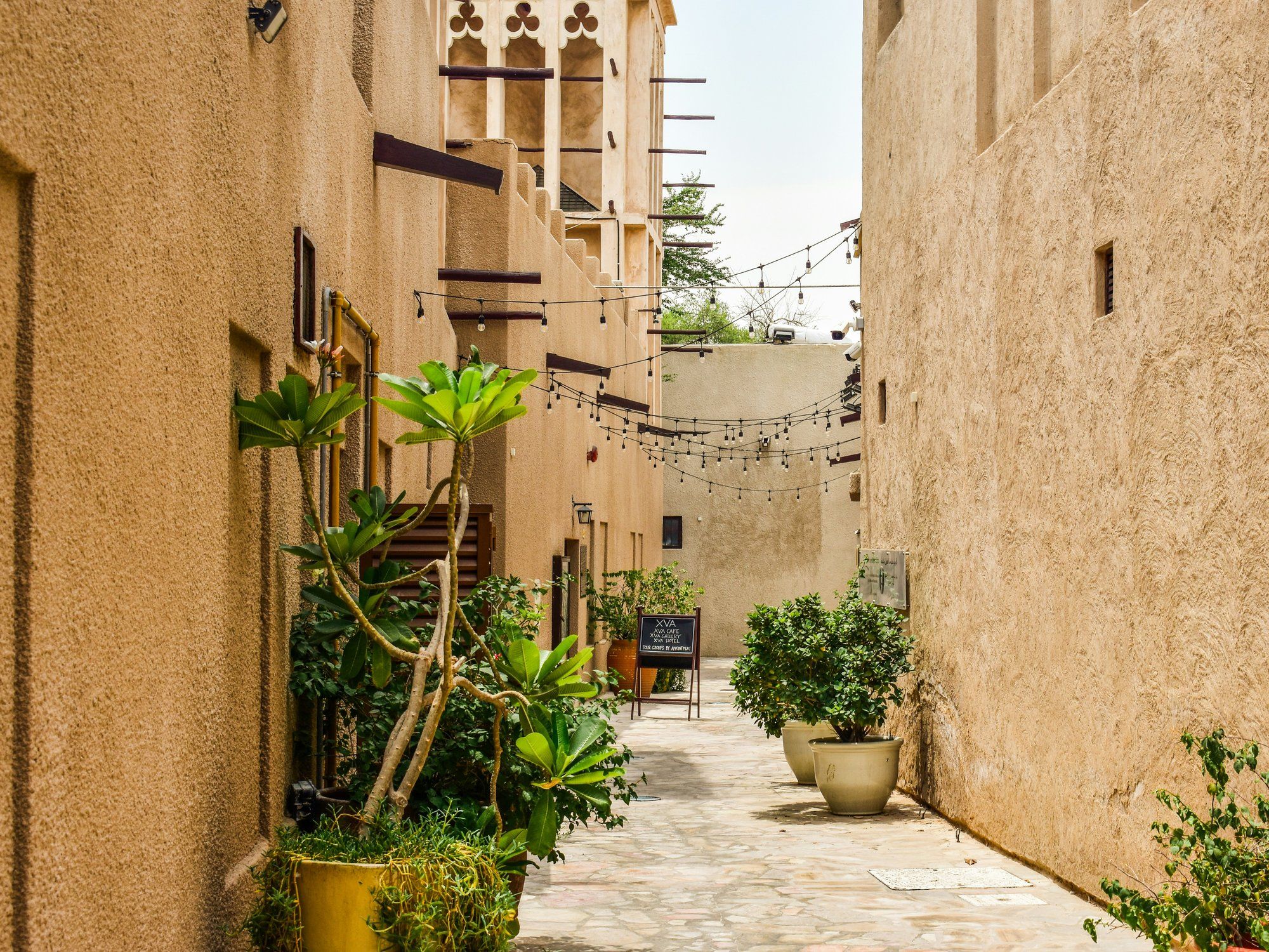 A narrow lane in the Al Fahidi Historical Neighbourhood, lined with traditional coral-and-gypsum buildings and wind towers
