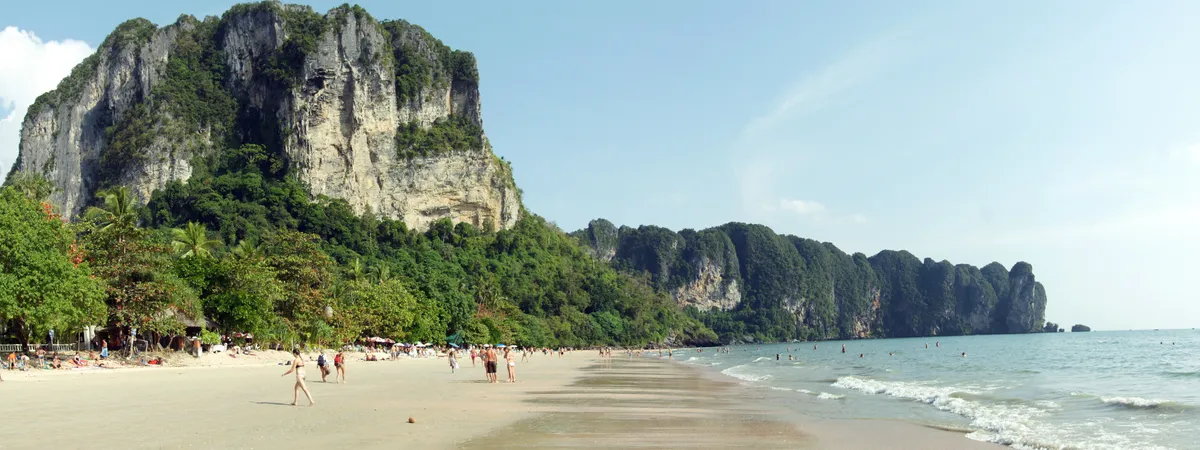 Ao Nang beach with longtail boats and limestone islands offshore, Krabi