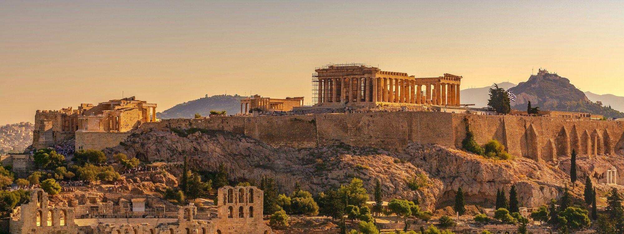 The Acropolis of Athens at golden hour, with the Parthenon and Erechtheion above and the Odeon of Herodes Atticus below