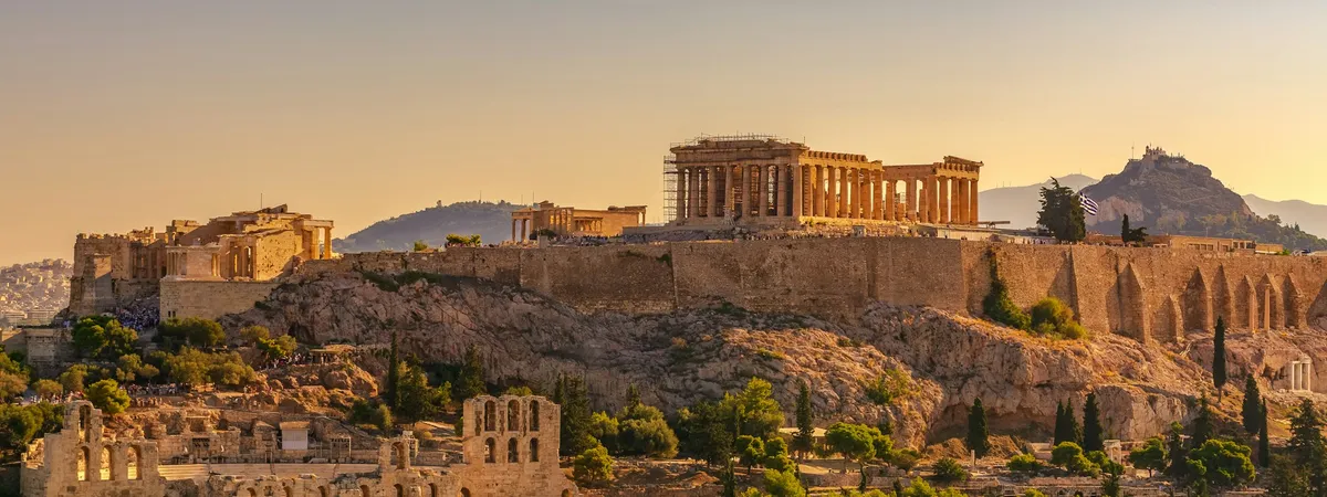 The Acropolis of Athens at golden hour, with the Parthenon and Erechtheion above and the Odeon of Herodes Atticus below