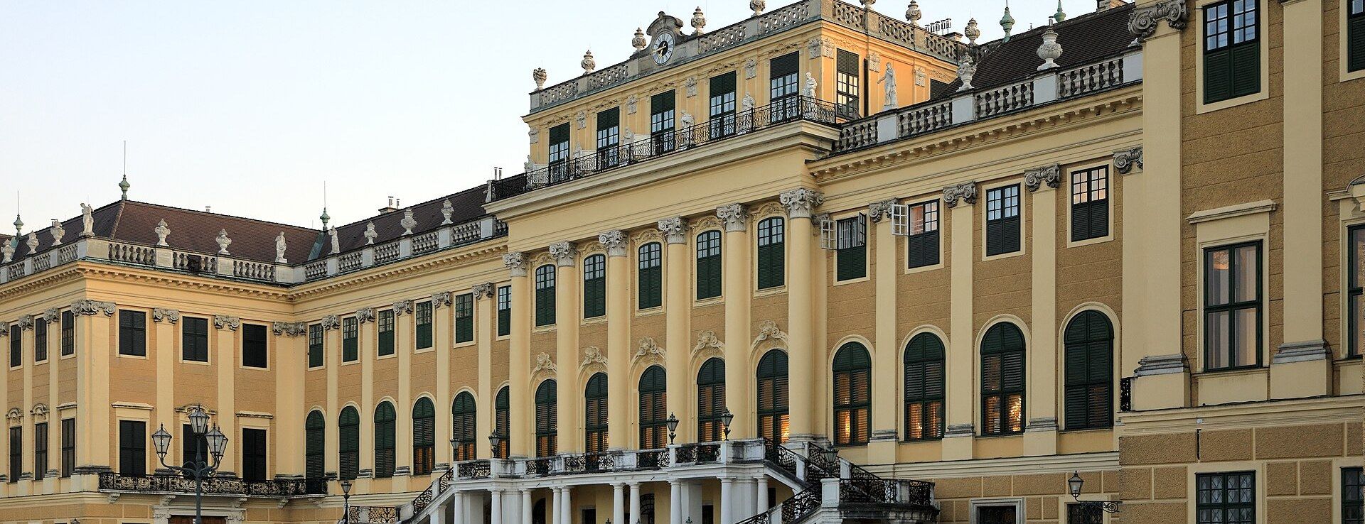 The main courtyard facade of Schönbrunn Palace in Vienna, lit at golden hour