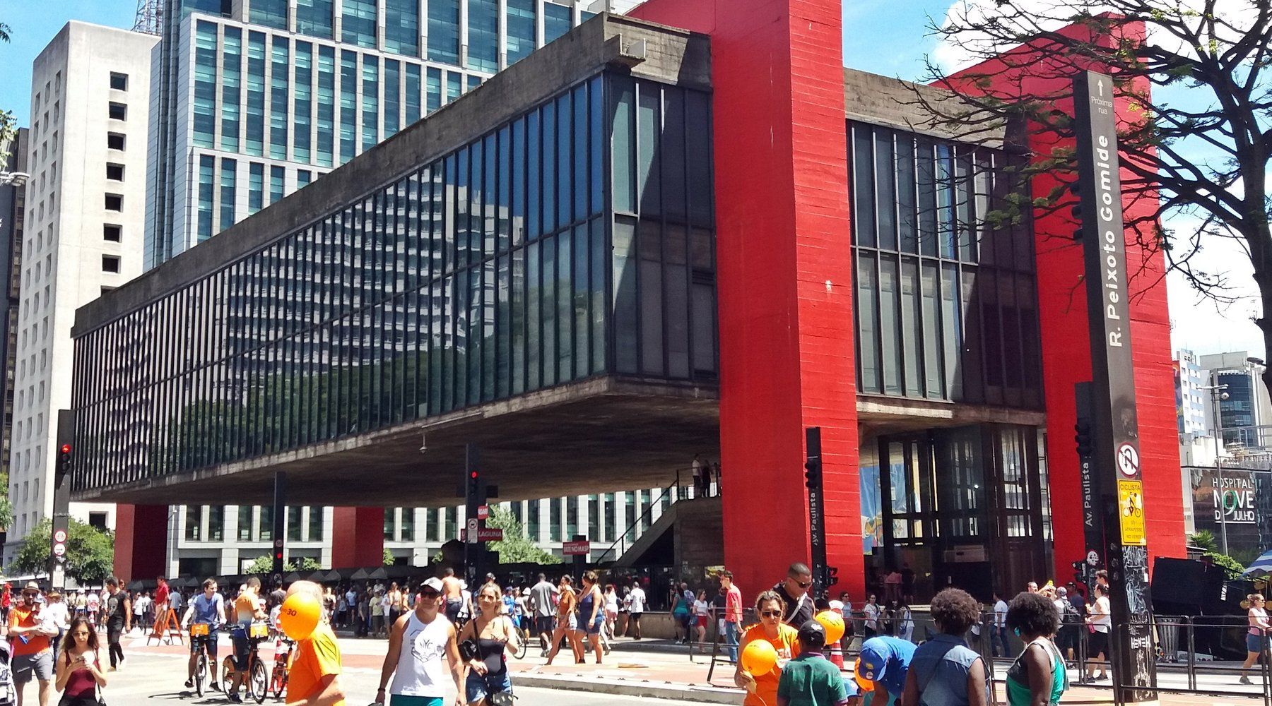 The raised red-and-glass MASP building suspended over its plaza on Avenida Paulista, crowded with pedestrians