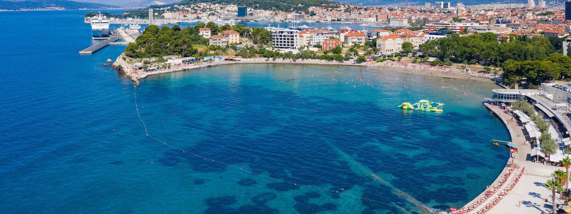 Aerial view of Bačvice's sandy beach cove with the city of Split in the background