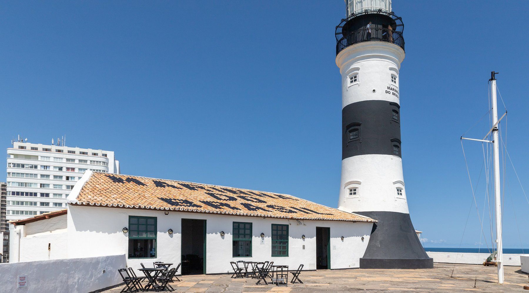 El faro de Farol da Barra, a rayas blancas y negras, elevándose sobre su fuerte encalado en la costa de Salvador