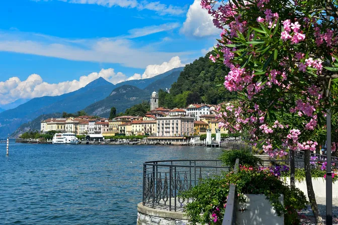 Bellagio's waterfront on Lake Como with a ferry at the pier and oleander in the foreground
