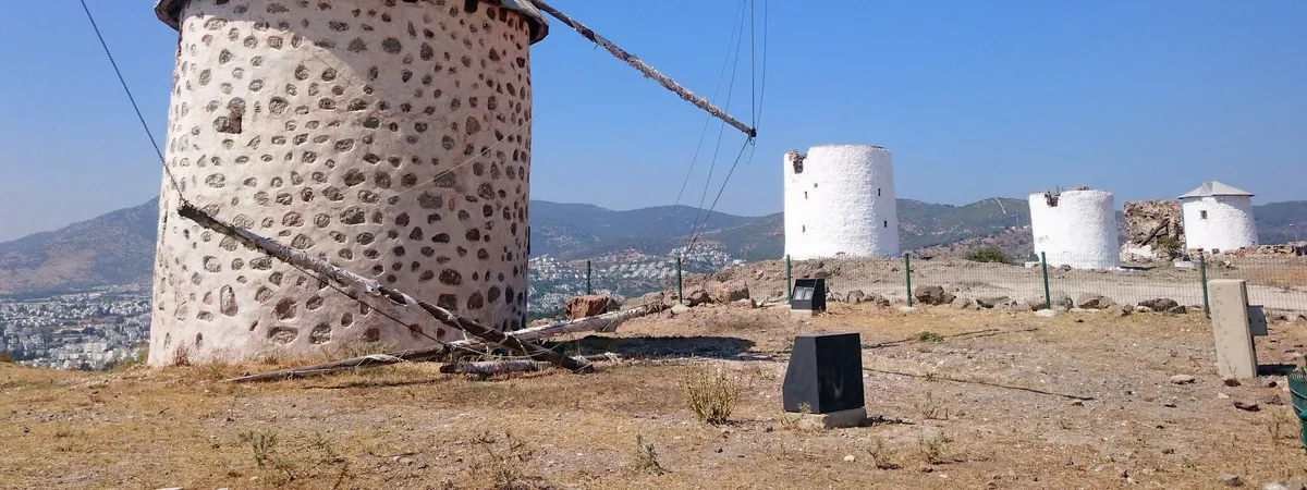 שורת טחנות רוח מאבן לבנה מסורתיות על הגבעה מעל בודרום טאון, המשקיפה על חצי האי