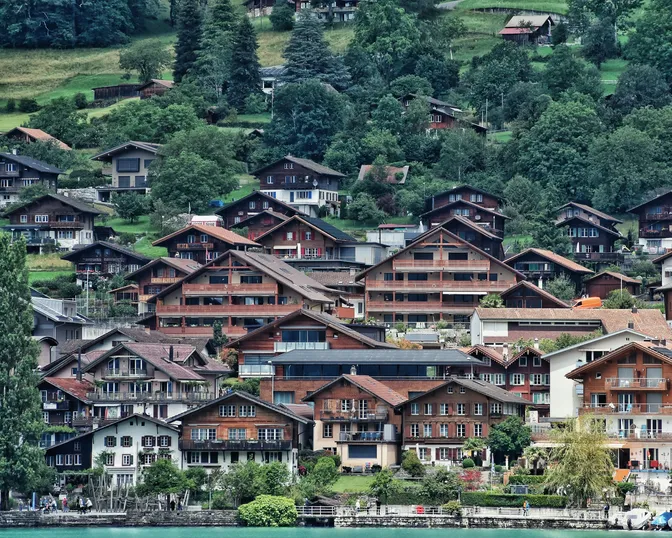 Dark wooden chalets stacked on the hillside above the water at Brienz, on Lake Brienz