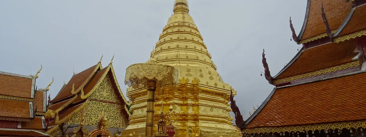The golden chedi of Wat Phra That Doi Suthep against the sky, on the mountain overlooking Chiang Mai