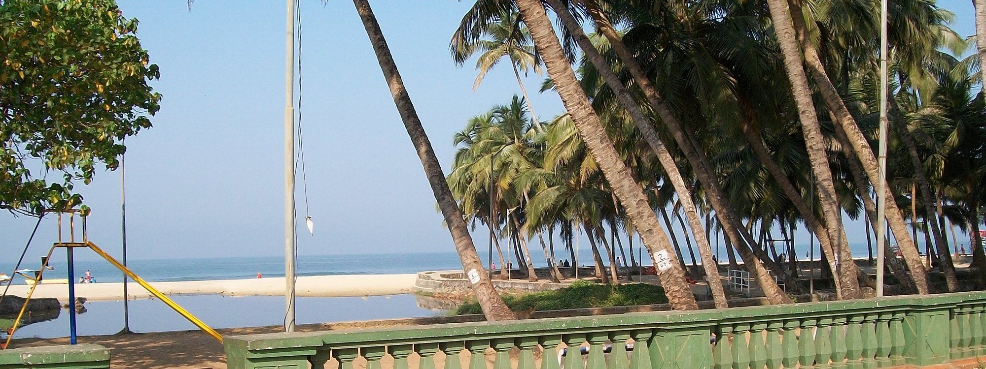 Palmeras y una torre de vigilancia junto al paseo de la playa de Colva