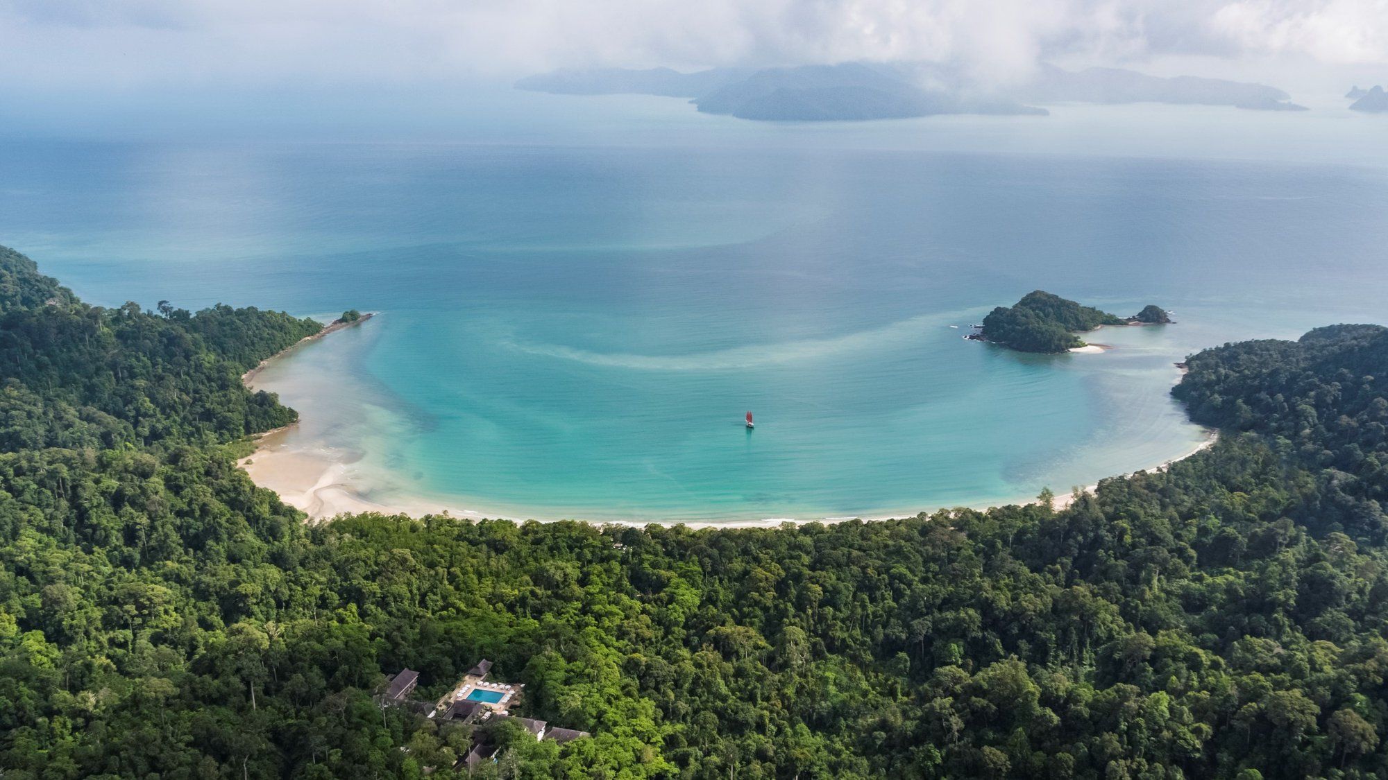 Datai Bay's crescent of white sand and turquoise water, framed by ancient rainforest, in northwest Langkawi