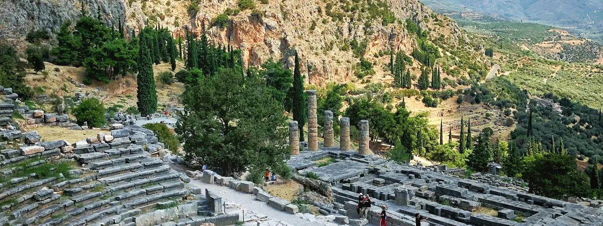 Delphi's ancient theatre and the Temple of Apollo's columns set into the slope of Mount Parnassus