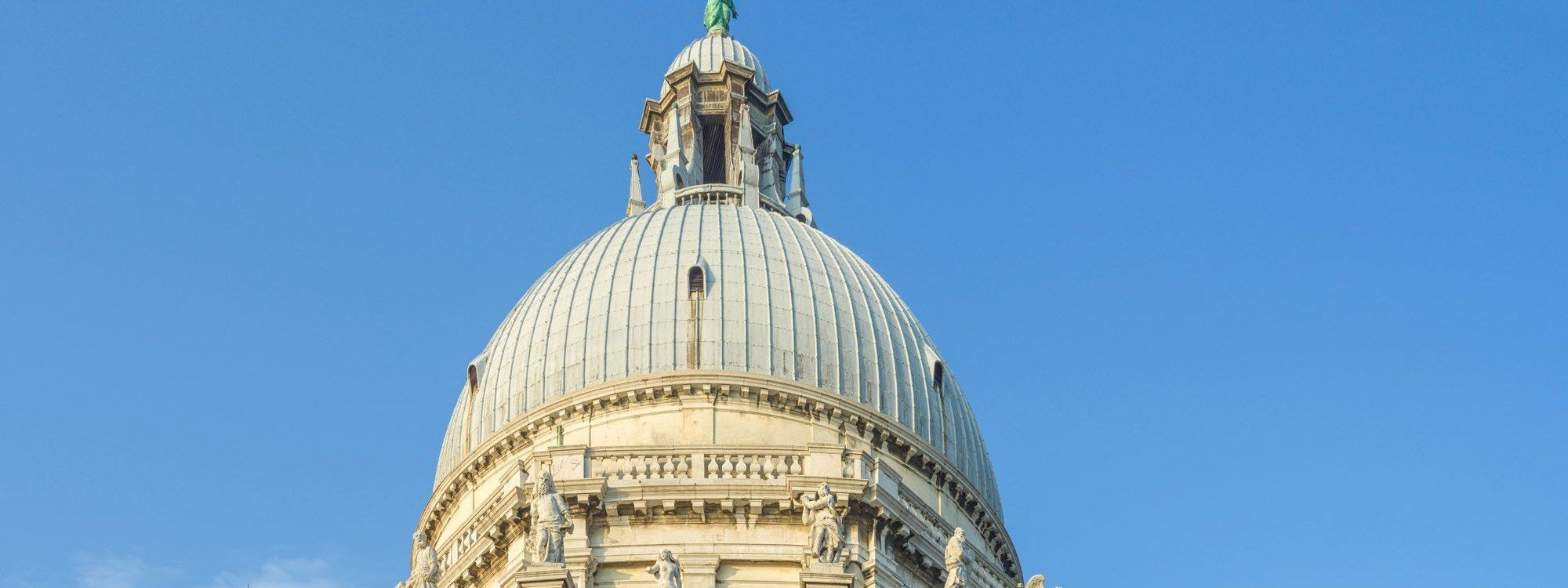 The ribbed dome and lantern of the Basilica of Santa Maria della Salute in Dorsoduro, Venice, against a clear blue sky