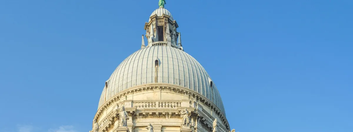 The ribbed dome and lantern of the Basilica of Santa Maria della Salute in Dorsoduro, Venice, against a clear blue sky