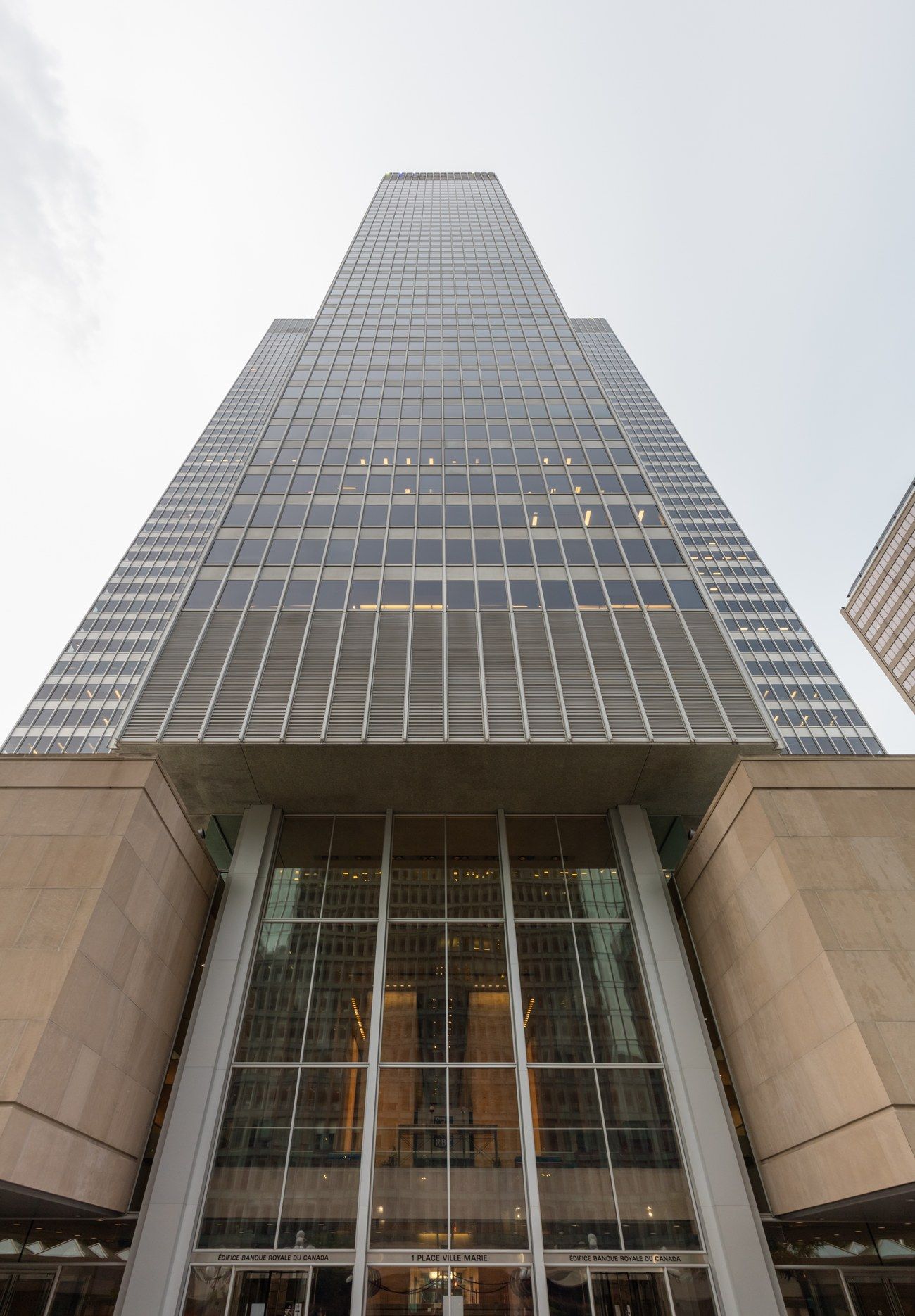 Looking straight up at 1 Place Ville Marie's cruciform office tower in downtown Montreal, with its ground-floor entrance sign visible
