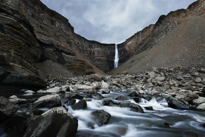 Hengifoss dropping through its red-and-black striped canyon walls near Egilsstaðir
