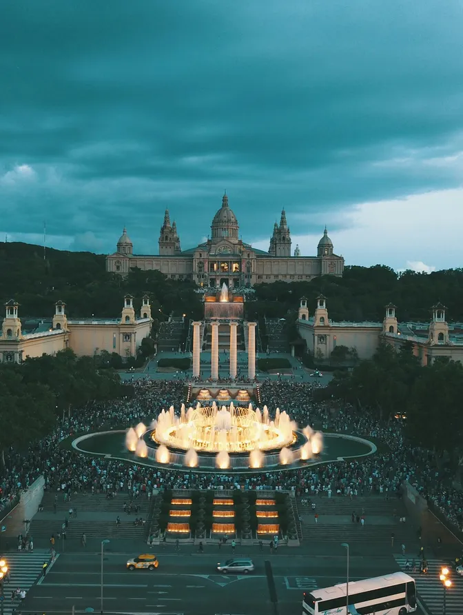 Los chorros iluminados de la Font Màgica frente al Palau Nacional al anochecer