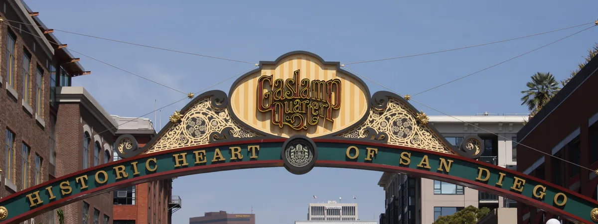 The illuminated "Gaslamp Quarter — Historic Heart of San Diego" arch sign spanning 5th Avenue, with downtown high-rises behind it