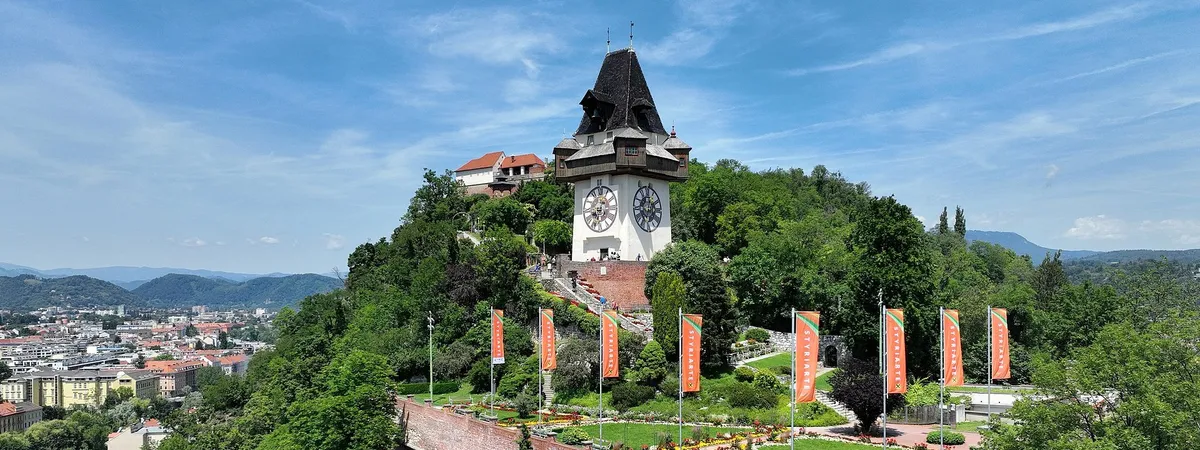 The Uhrturm clock tower atop Graz's Schlossberg hill, overlooking the old town's red rooftops