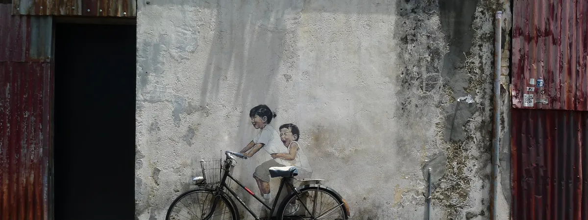 Ernest Zacharevic's 'Children on a Bicycle' mural, with a real bicycle mounted on the wall, on Armenian Street in George Town