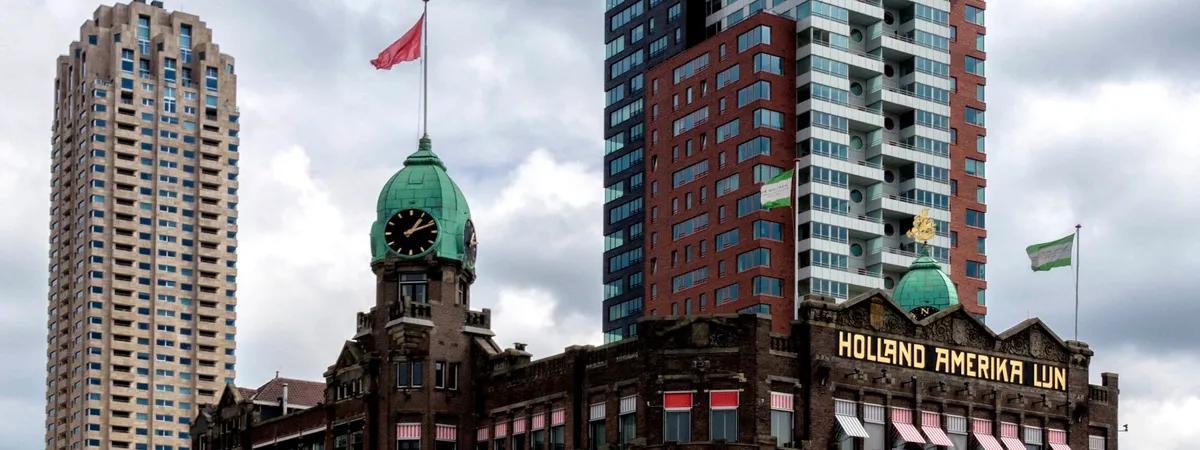 Hotel New York's former Holland America Line headquarters building on Wilhelminapier, with modern high-rise towers behind it