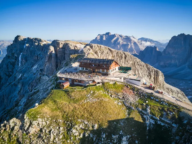 Rifugio Lagazuoi and its terrace on the summit ridge of the Lagazuoi, with the Tofane and Fanes peaks behind