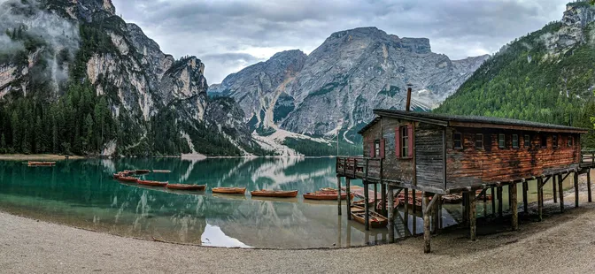 The wooden boathouse and moored rowing boats at Lago di Braies, the Seekofel closing the far end of the lake