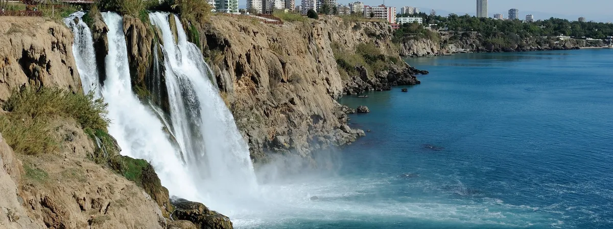 The Lower Düden Waterfall dropping about 40 meters off the cliffs directly into the Mediterranean Sea, with the Lara coastline in the background