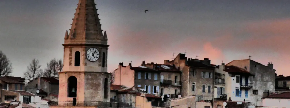 The bell tower of Notre-Dame-des-Accoules rising above the rooftops of Le Panier, Marseille's old town, at dusk