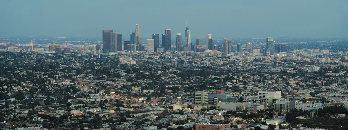 Downtown Los Angeles skyline at dusk, seen from Griffith Observatory with the city spreading out below toward the horizon