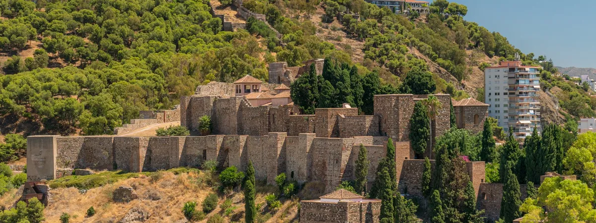 The Alcazaba fortress on its hillside above Málaga's old town, with the Gibralfaro castle walls visible on the summit behind it