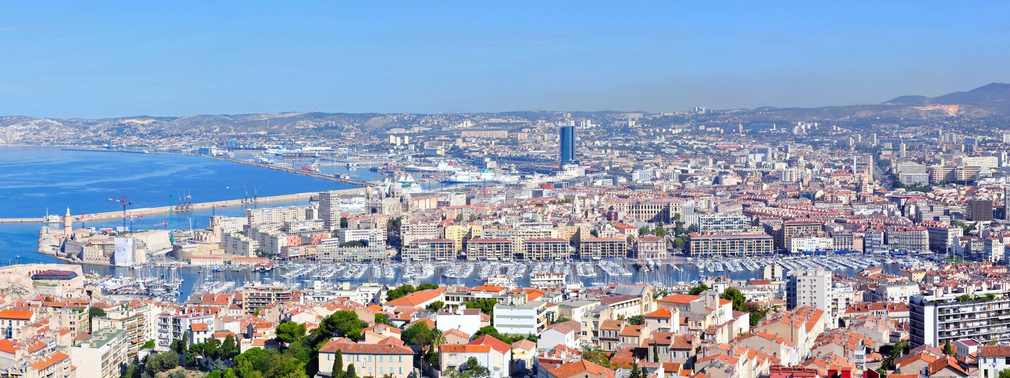 Aerial view from Notre-Dame de la Garde over Marseille's Vieux-Port, its marina packed with boats, and the city stretching out behind it