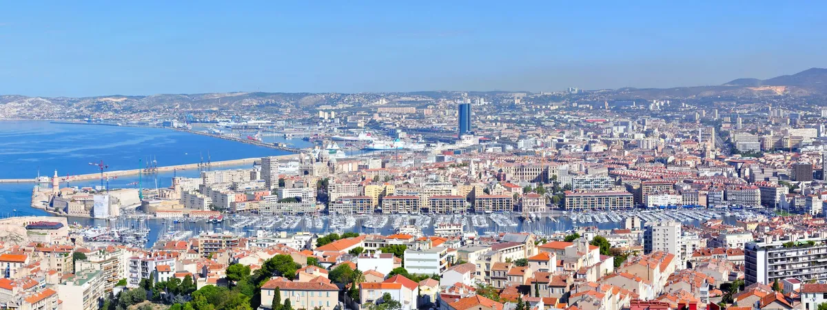 Aerial view from Notre-Dame de la Garde over Marseille's Vieux-Port, its marina packed with boats, and the city stretching out behind it
