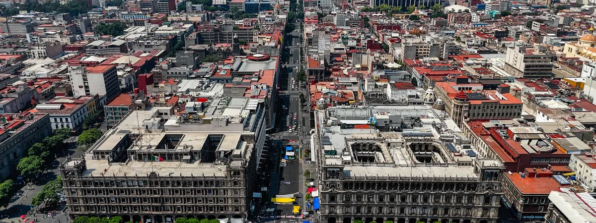 Aerial view of the Zócalo in Mexico City's historic center, with the Palacio Nacional and Antiguo Palacio del Ayuntamiento framing the plaza