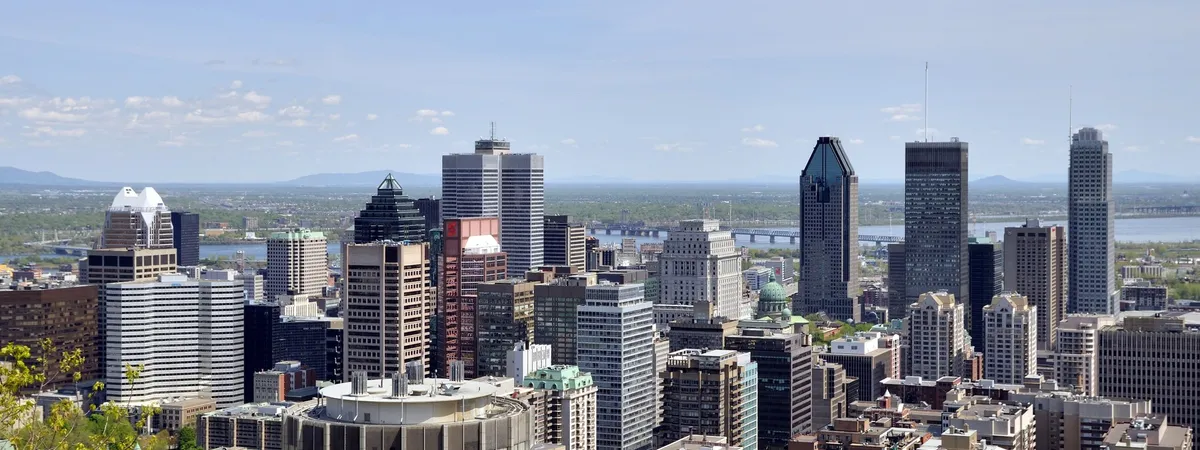 Downtown Montreal's skyscraper skyline seen from Mount Royal, with the Saint Lawrence River and its bridges in the distance