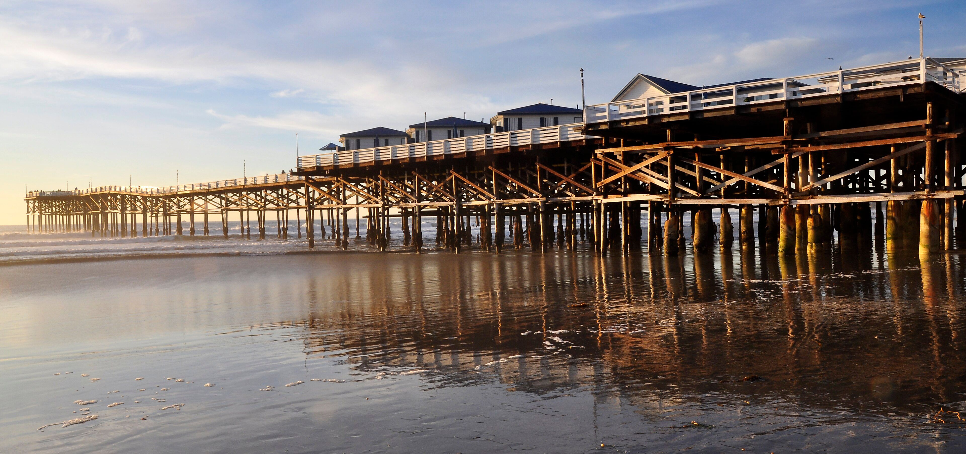 Crystal Pier's over-water cottages and wooden pilings at low tide in Pacific Beach, San Diego