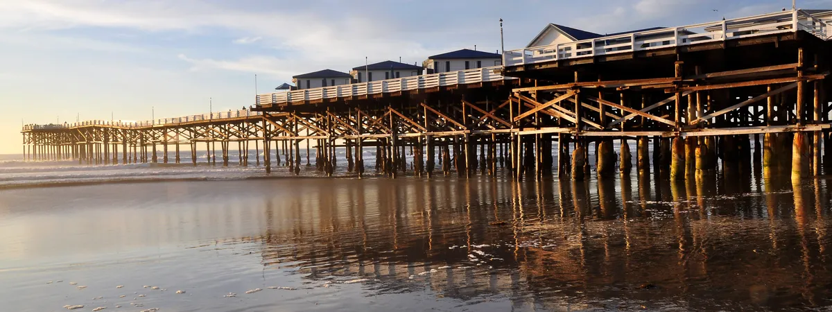 Crystal Pier's over-water cottages and wooden pilings at low tide in Pacific Beach, San Diego