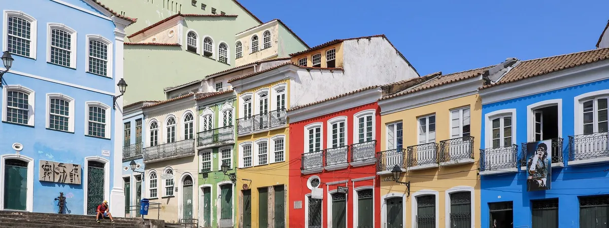 Una fila de casonas coloniales de colores en azul, verde, rojo y amarillo a lo largo del adoquinado Largo do Pelourinho