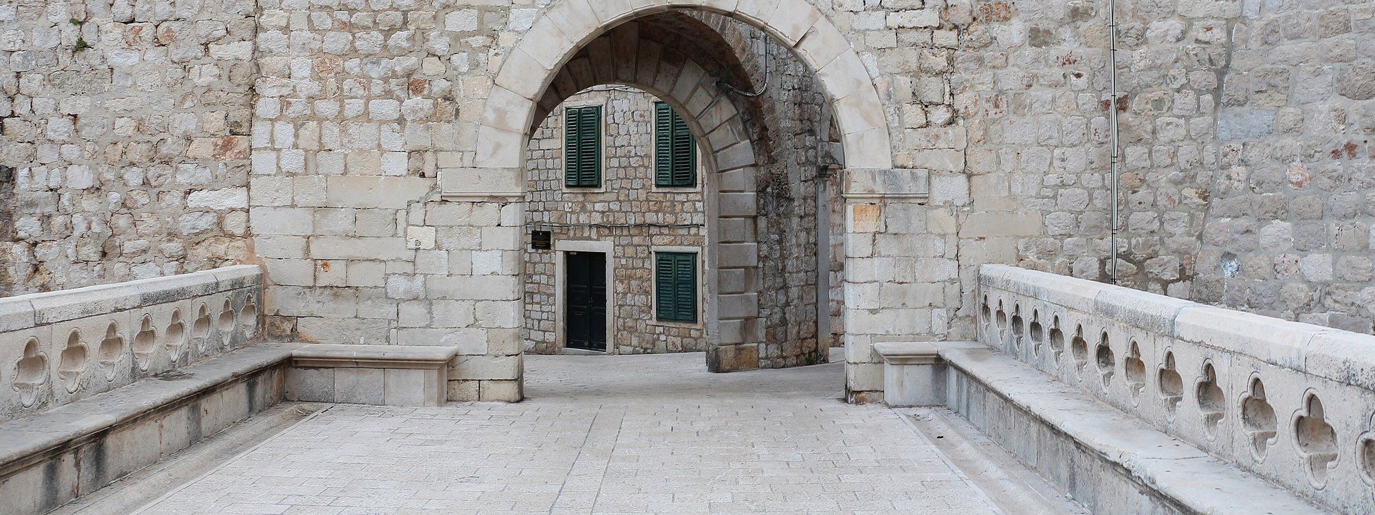 The stone archway of Ploče Gate, one of the historic entrances to Dubrovnik's Old Town, leading toward the Ploče district