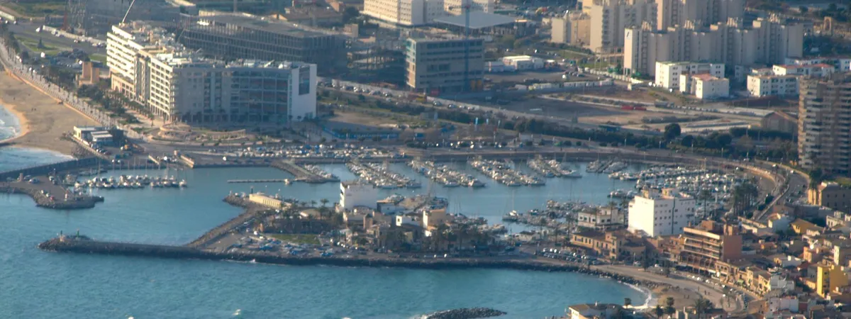 Aerial view of the Es Portitxol marina and breakwater, with its small beach and harborfront promenade