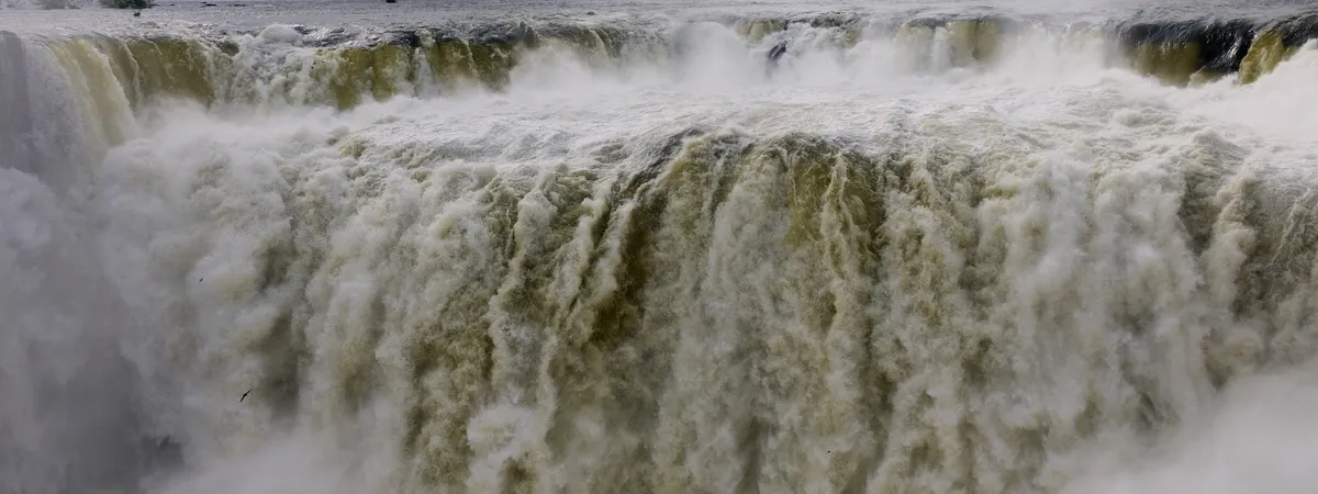 La Garganta del Diablo en las Cataratas del Iguazú, vista desde el mirador argentino, con el agua del río Iguazú cayendo por el borde del acantilado entre la espuma