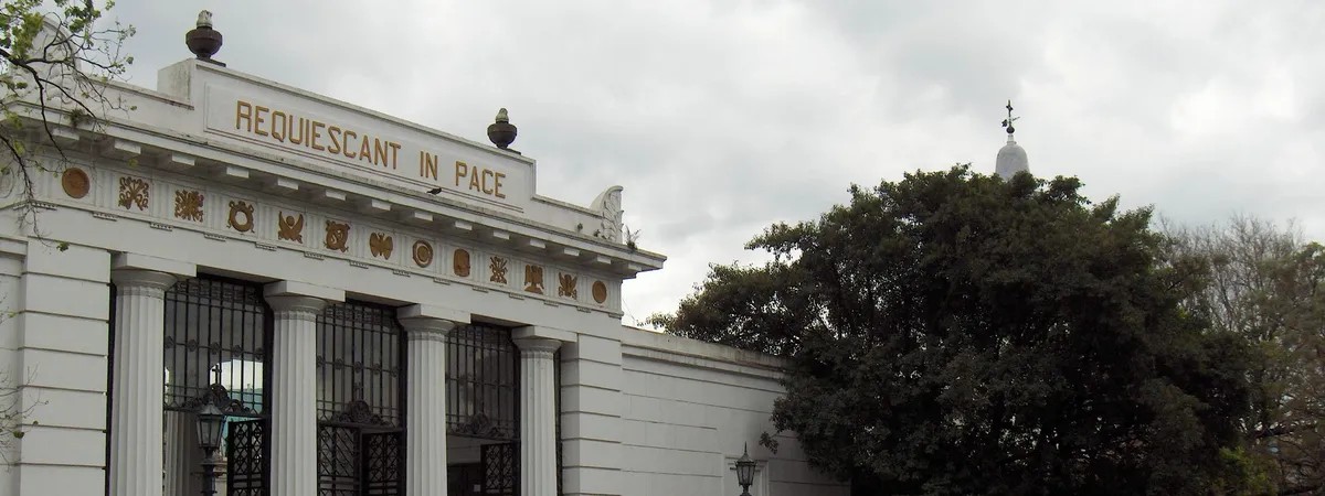 The neoclassical entrance gate of Recoleta Cemetery, inscribed "Requiescant in Pace," seen through its columned portico
