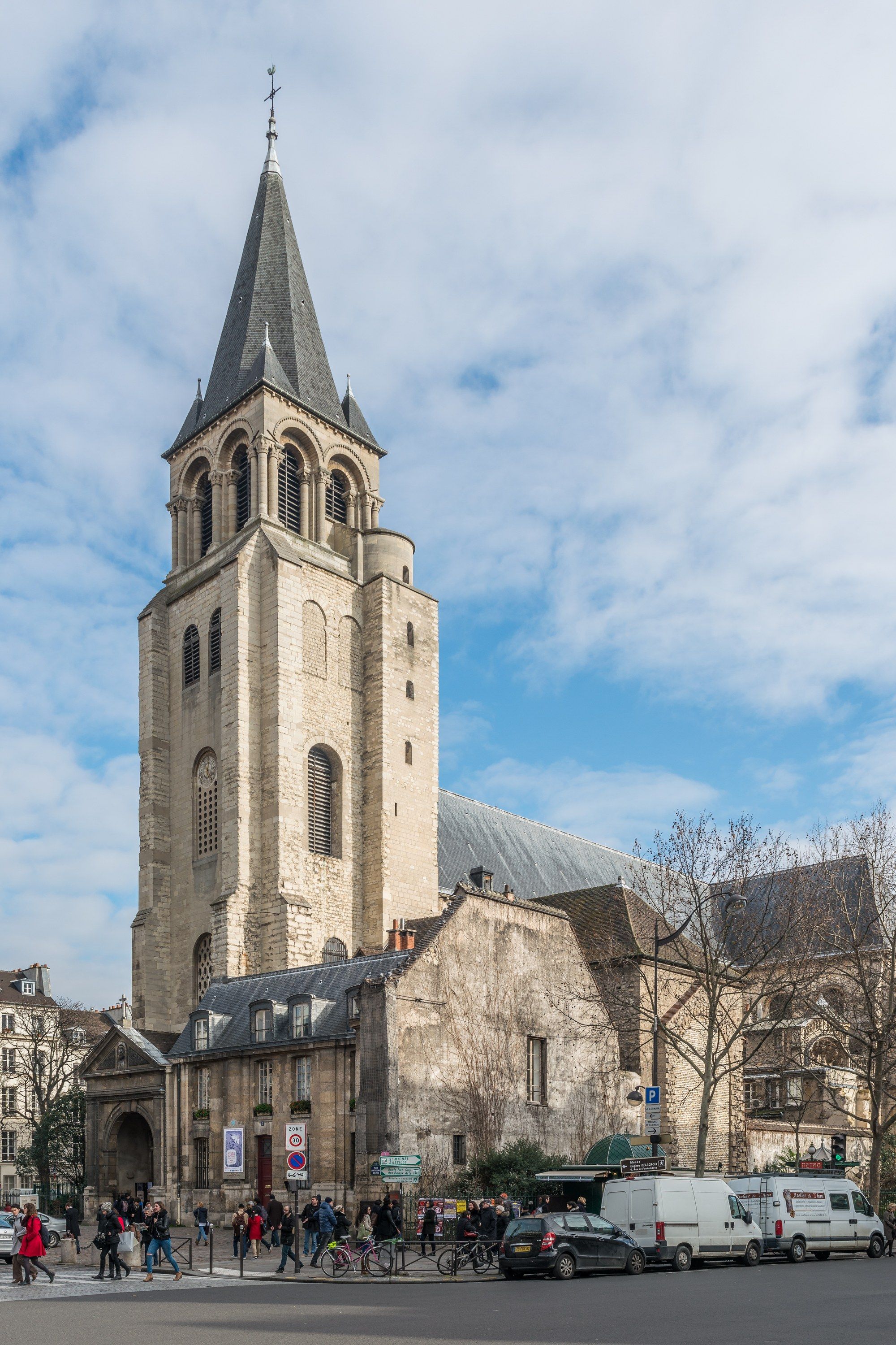 The Romanesque bell tower of the Saint-Germain-des-Prés church rising above the square, with pedestrians and surrounding buildings at street level