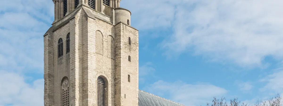 The Romanesque bell tower of the Saint-Germain-des-Prés church rising above the square, with pedestrians and surrounding buildings at street level