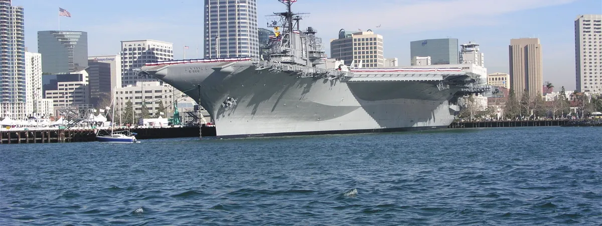 The USS Midway aircraft carrier moored on San Diego Bay with the downtown skyline behind it