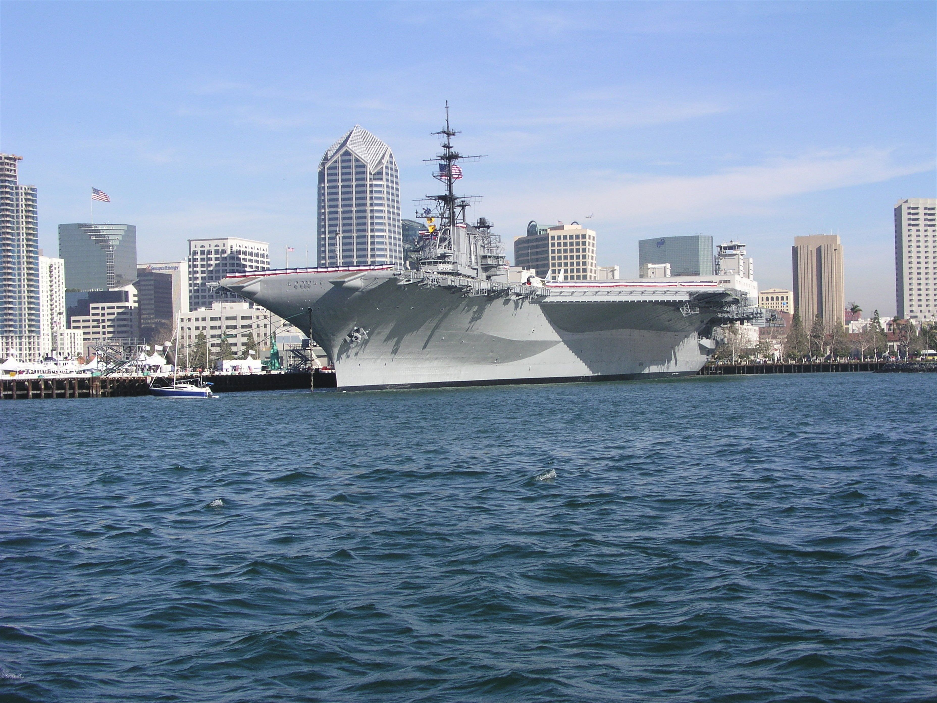 The USS Midway aircraft carrier moored on San Diego Bay with the downtown skyline behind it
