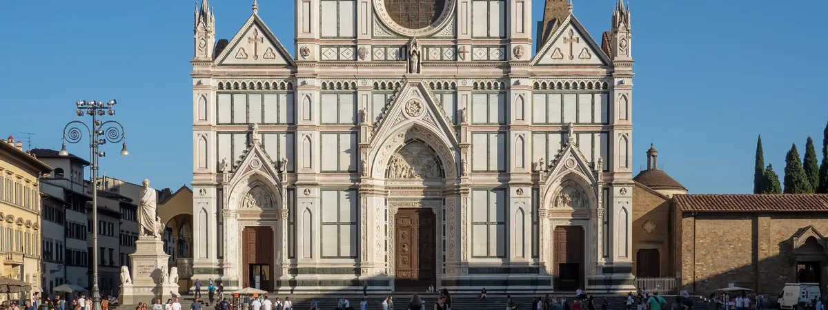 The white, green, and pink marble facade of the Basilica di Santa Croce in Florence, with its Gothic gables and rose window