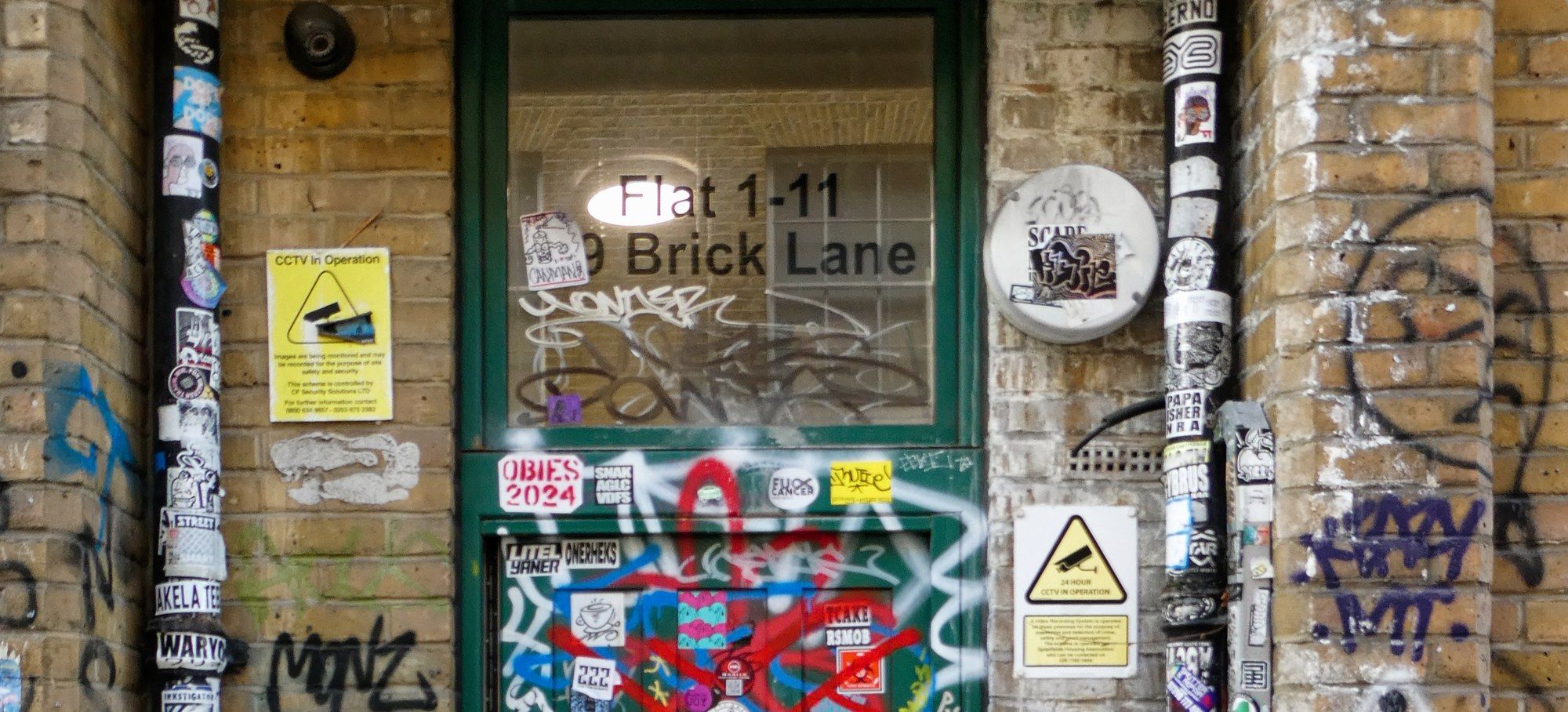 A sticker- and graffiti-covered doorway on Brick Lane in Shoreditch, East London